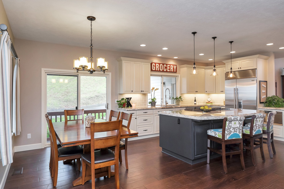 Example of a transitional dark wood floor eat-in kitchen design in Portland with white backsplash, stainless steel appliances and an island