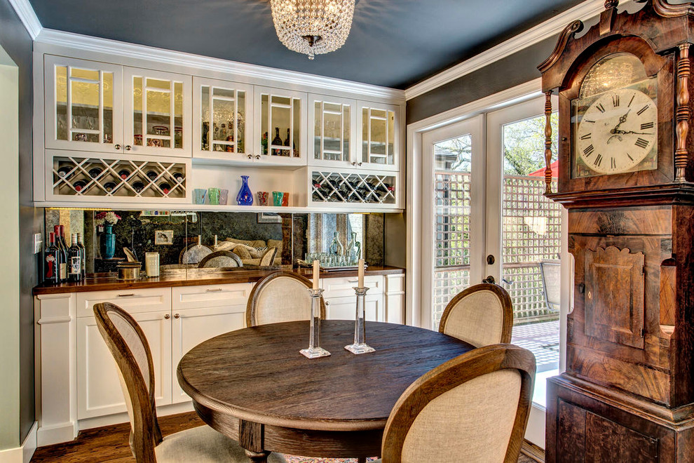 Immagine di una cucina classica chiusa con ante di vetro, ante bianche, top in legno, paraspruzzi bianco e paraspruzzi a specchio