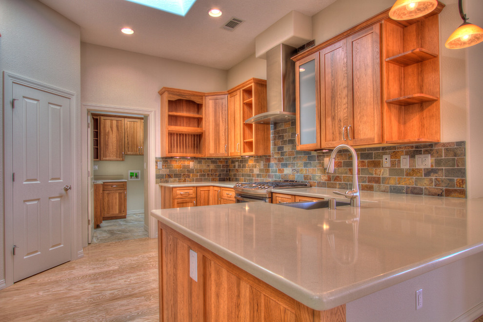 Small elegant l-shaped light wood floor kitchen photo in Albuquerque with a farmhouse sink, shaker cabinets, medium tone wood cabinets, quartz countertops, multicolored backsplash, stone tile backsplash, stainless steel appliances and no island