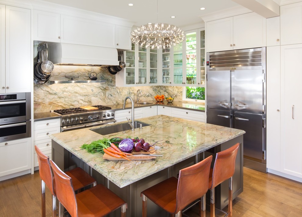 Large trendy l-shaped medium tone wood floor and beige floor eat-in kitchen photo in San Francisco with an integrated sink, glass-front cabinets, white cabinets, quartzite countertops, multicolored backsplash, stainless steel appliances, an island and stone slab backsplash