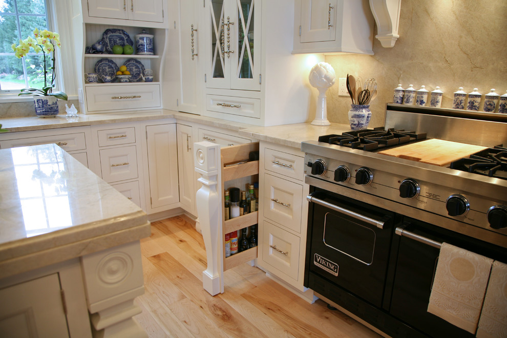 Klassische Küche in U-Form mit weißen Schränken, braunem Holzboden und zwei Kücheninseln in Chicago