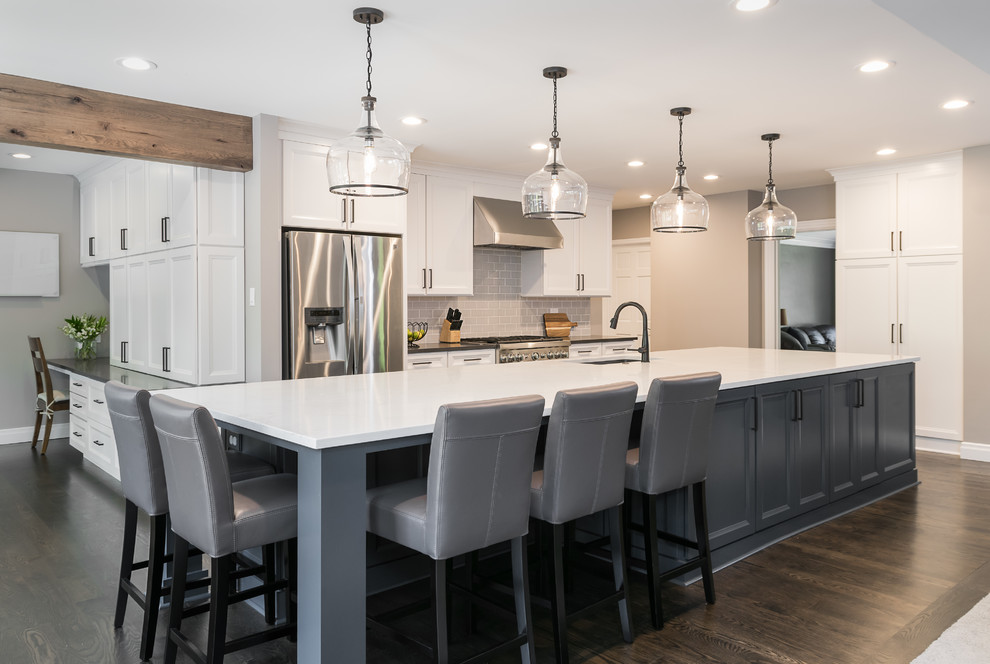 Moderne Wohnküche mit blauen Schränken, Küchengeräten aus Edelstahl, dunklem Holzboden, Kücheninsel, braunem Boden und weißer Arbeitsplatte in St. Louis