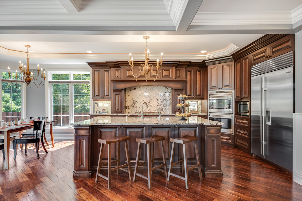 Eat-in kitchen - traditional medium tone wood floor eat-in kitchen idea in Chicago with raised-panel cabinets, dark wood cabinets, multicolored backsplash, stone slab backsplash, stainless steel appliances, an island and multicolored countertops