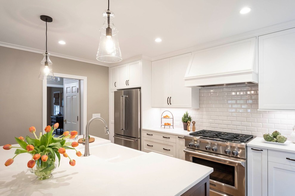 Exempel på ett mellanstort klassiskt vit vitt kök, med en rustik diskho, skåp i shakerstil, vita skåp, bänkskiva i kvarts, vitt stänkskydd, stänkskydd i keramik, rostfria vitvaror, mellanmörkt trägolv, en köksö och brunt golv