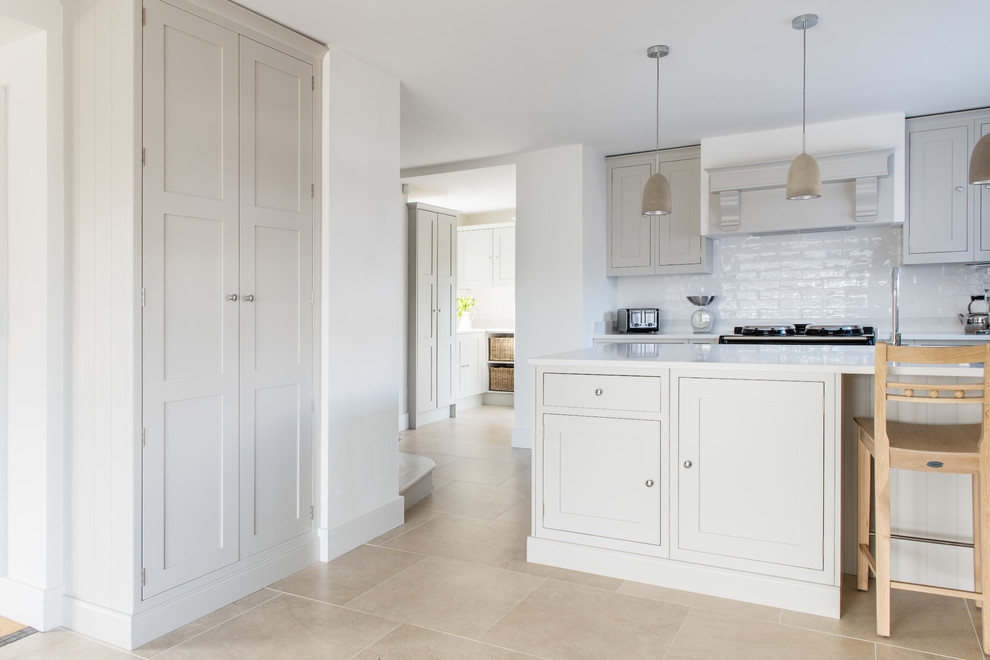 Design ideas for a medium sized traditional galley open plan kitchen in Devon with a built-in sink, shaker cabinets, grey cabinets, composite countertops, grey splashback, ceramic splashback, stainless steel appliances, limestone flooring and a breakfast bar.