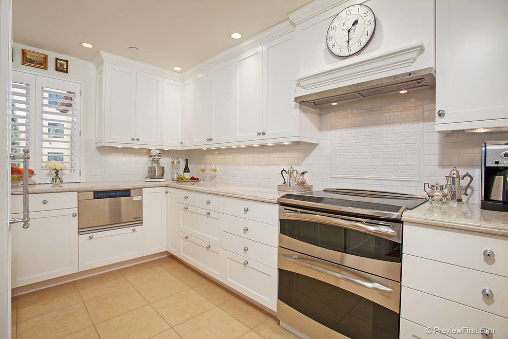 Example of a transitional enclosed kitchen design in San Diego with shaker cabinets, white cabinets, marble countertops, white backsplash, subway tile backsplash and stainless steel appliances