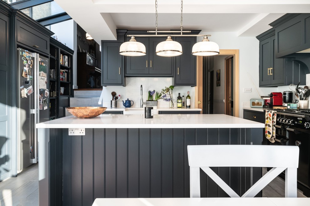 Design ideas for a small contemporary u-shaped kitchen in London with a belfast sink, recessed-panel cabinets, blue cabinets, quartz worktops, white splashback, an island and white worktops.