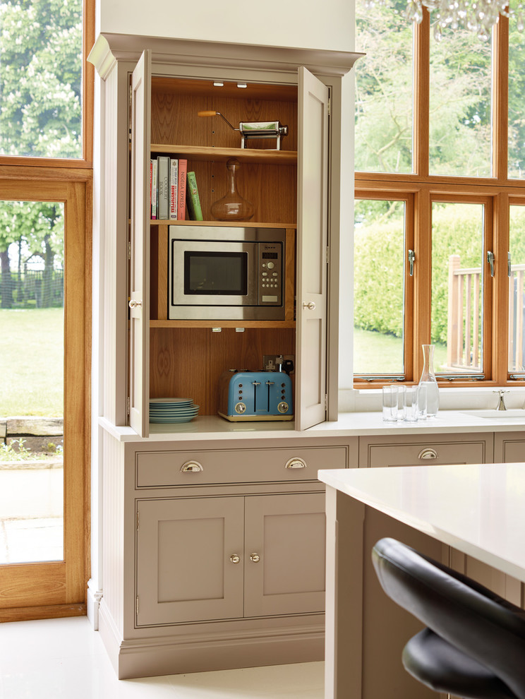 Photo of a medium sized farmhouse kitchen/diner in Manchester with shaker cabinets, grey cabinets and an island.