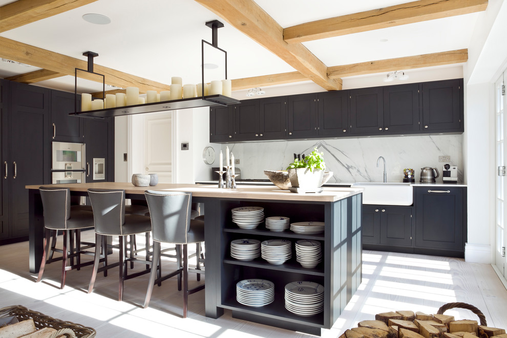 Exempel på ett stort skandinaviskt kök, med en rustik diskho, skåp i shakerstil, svarta skåp, vitt stänkskydd, stänkskydd i marmor, integrerade vitvaror, ljust trägolv, en köksö, beiget golv och träbänkskiva