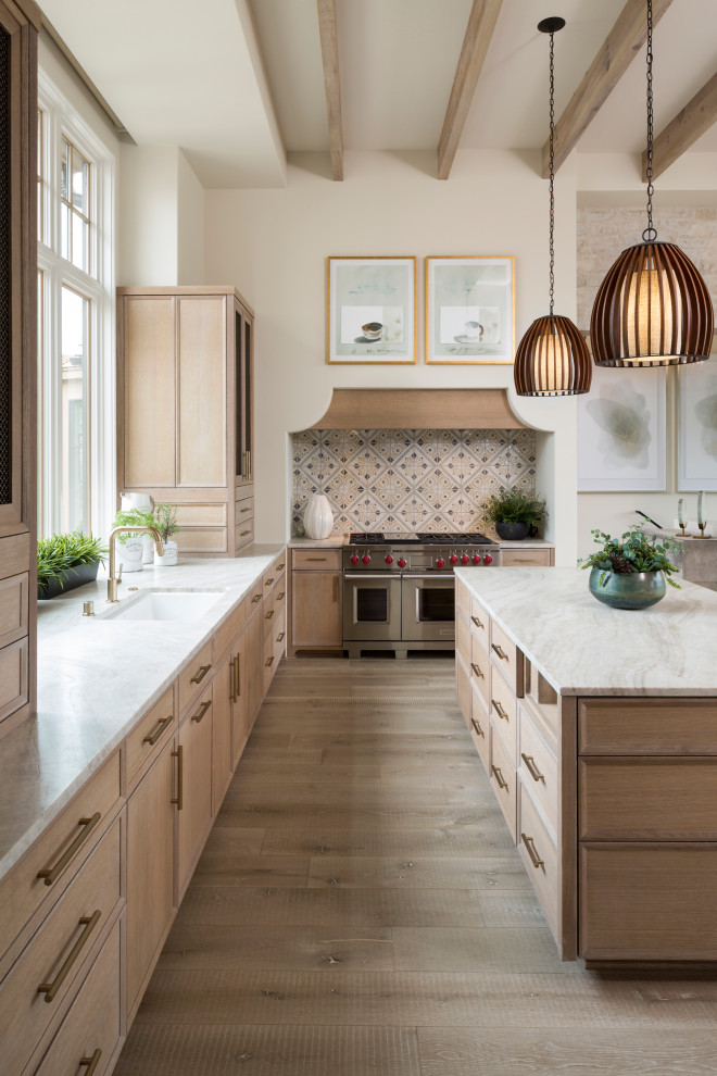 Inspiration for a transitional l-shaped light wood floor and exposed beam kitchen remodel in Minneapolis with an undermount sink, light wood cabinets, multicolored backsplash, stainless steel appliances, an island and white countertops