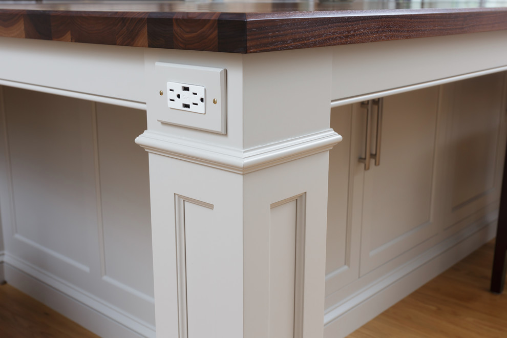 Large elegant u-shaped light wood floor and beige floor enclosed kitchen photo in Philadelphia with an undermount sink, recessed-panel cabinets, white cabinets, marble countertops, white backsplash, marble backsplash, paneled appliances and two islands