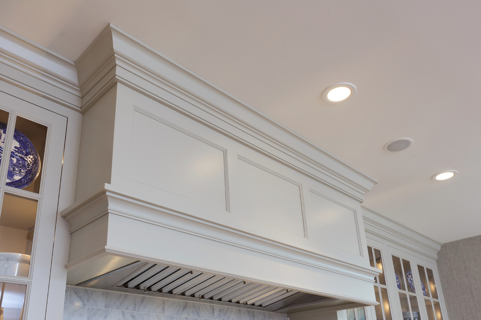 Example of a large classic u-shaped light wood floor and beige floor enclosed kitchen design in Philadelphia with an undermount sink, recessed-panel cabinets, white cabinets, marble countertops, white backsplash, marble backsplash, paneled appliances and two islands