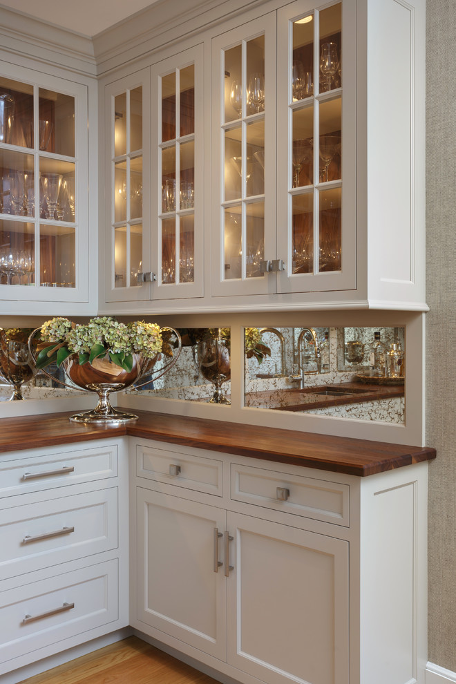 Example of a large classic u-shaped light wood floor and beige floor enclosed kitchen design in Philadelphia with an undermount sink, recessed-panel cabinets, white cabinets, marble countertops, white backsplash, marble backsplash, paneled appliances and two islands