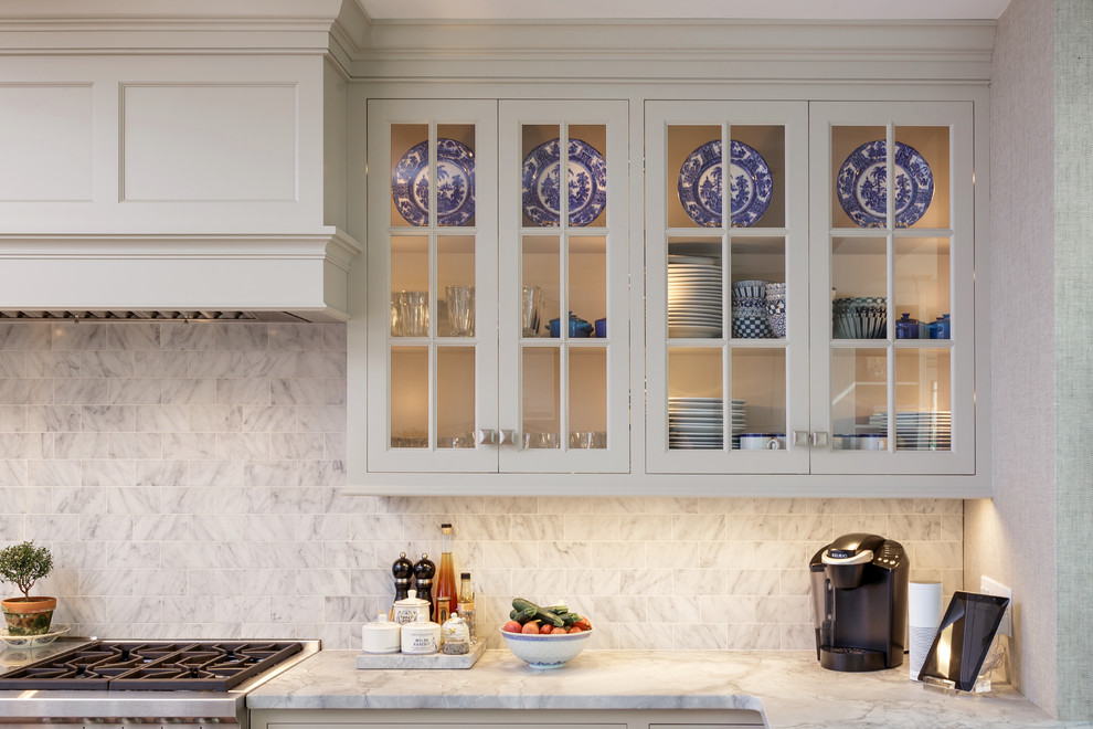 Enclosed kitchen - large traditional u-shaped light wood floor and beige floor enclosed kitchen idea in Philadelphia with an undermount sink, recessed-panel cabinets, white cabinets, marble countertops, white backsplash, marble backsplash, paneled appliances and two islands