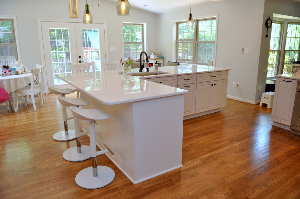 Idéer för att renovera ett mellanstort vintage kök, med en undermonterad diskho, luckor med upphöjd panel, vita skåp, bänkskiva i kvartsit, flerfärgad stänkskydd, stänkskydd i porslinskakel, rostfria vitvaror, ljust trägolv, en köksö och brunt golv