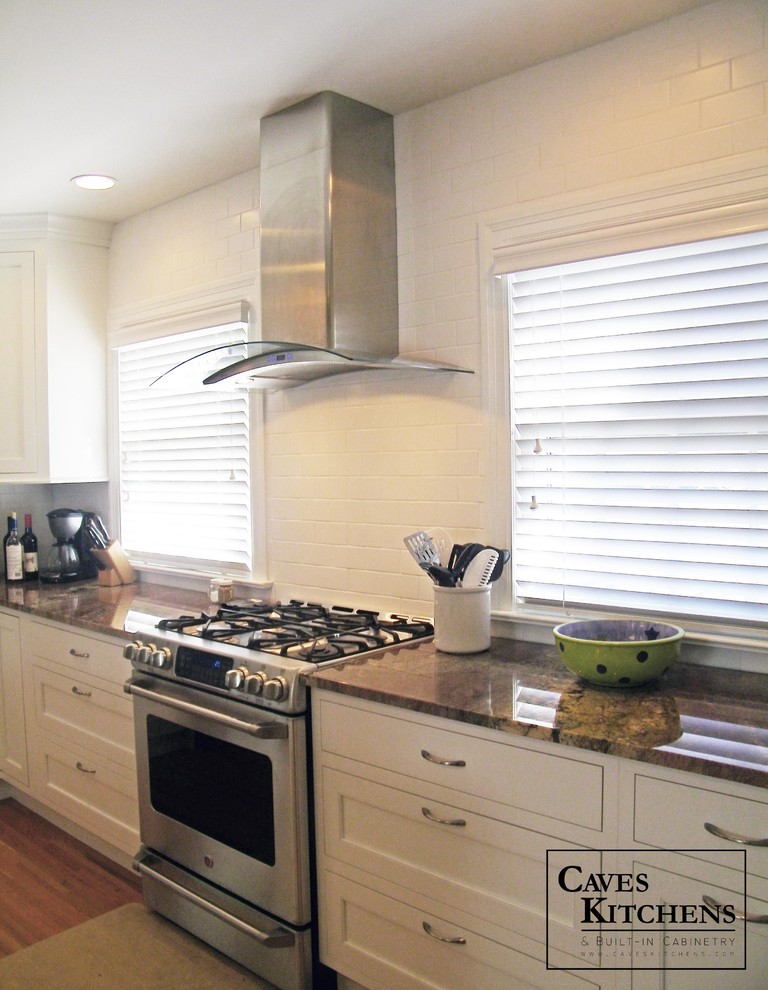 Example of a mid-sized trendy l-shaped medium tone wood floor eat-in kitchen design in New York with a single-bowl sink, recessed-panel cabinets, white cabinets, granite countertops, white backsplash, subway tile backsplash, stainless steel appliances and an island