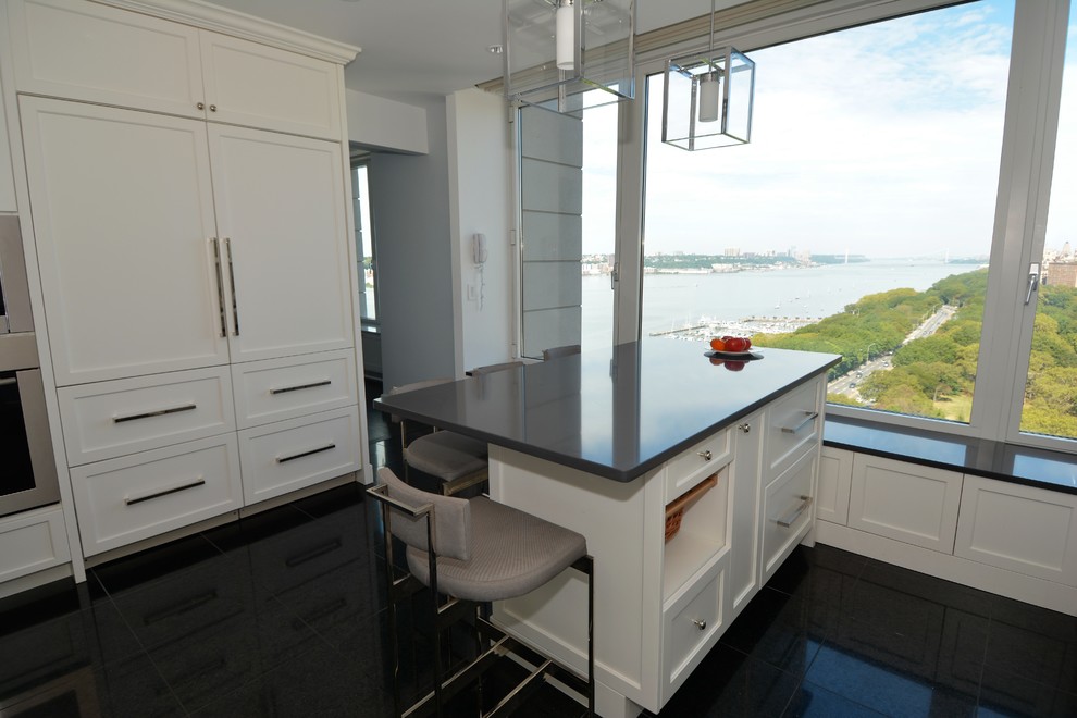 Example of a large trendy u-shaped eat-in kitchen design in New York with flat-panel cabinets, white cabinets, quartz countertops, white backsplash, stone slab backsplash, stainless steel appliances and an island