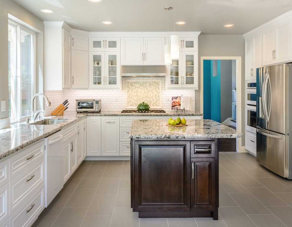 Inspiration for a traditional kitchen in San Francisco with a submerged sink, beaded cabinets, white cabinets, white splashback, metro tiled splashback, stainless steel appliances and an island.