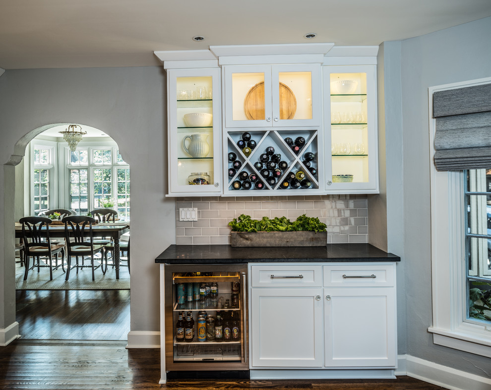 Eat-in kitchen - country l-shaped dark wood floor and brown floor eat-in kitchen idea in Indianapolis with a farmhouse sink, shaker cabinets, yellow cabinets, quartz countertops, gray backsplash, stone tile backsplash, stainless steel appliances and an island