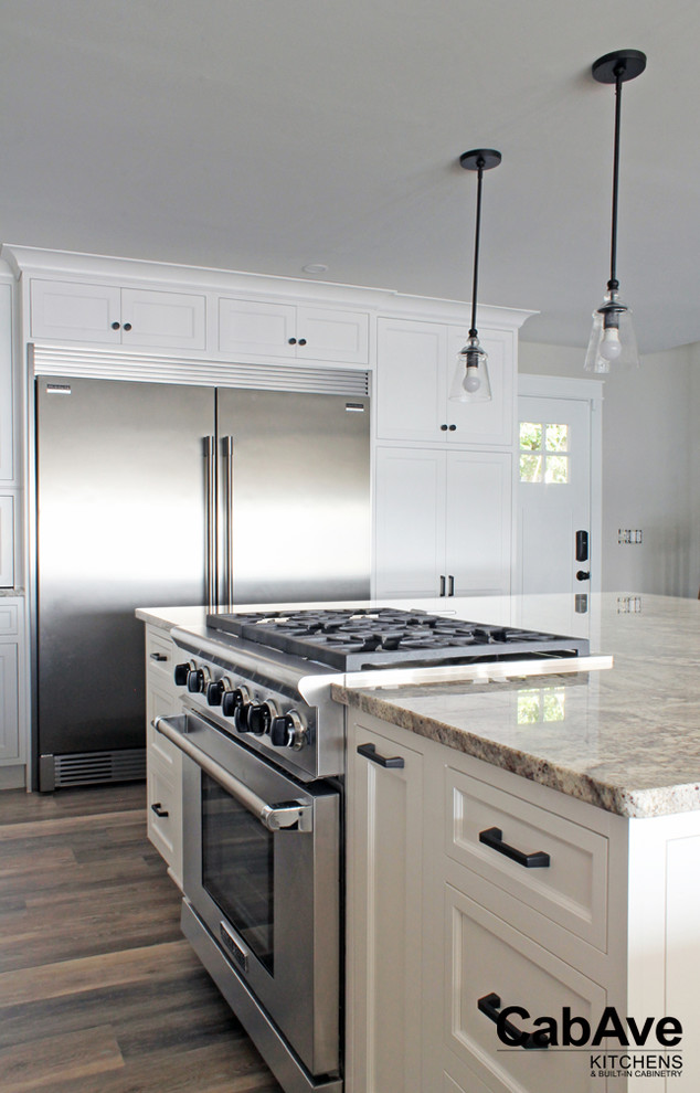 Exempel på ett stort maritimt kök, med en undermonterad diskho, släta luckor, vita skåp, granitbänkskiva, rostfria vitvaror, vinylgolv, en köksö och grått golv