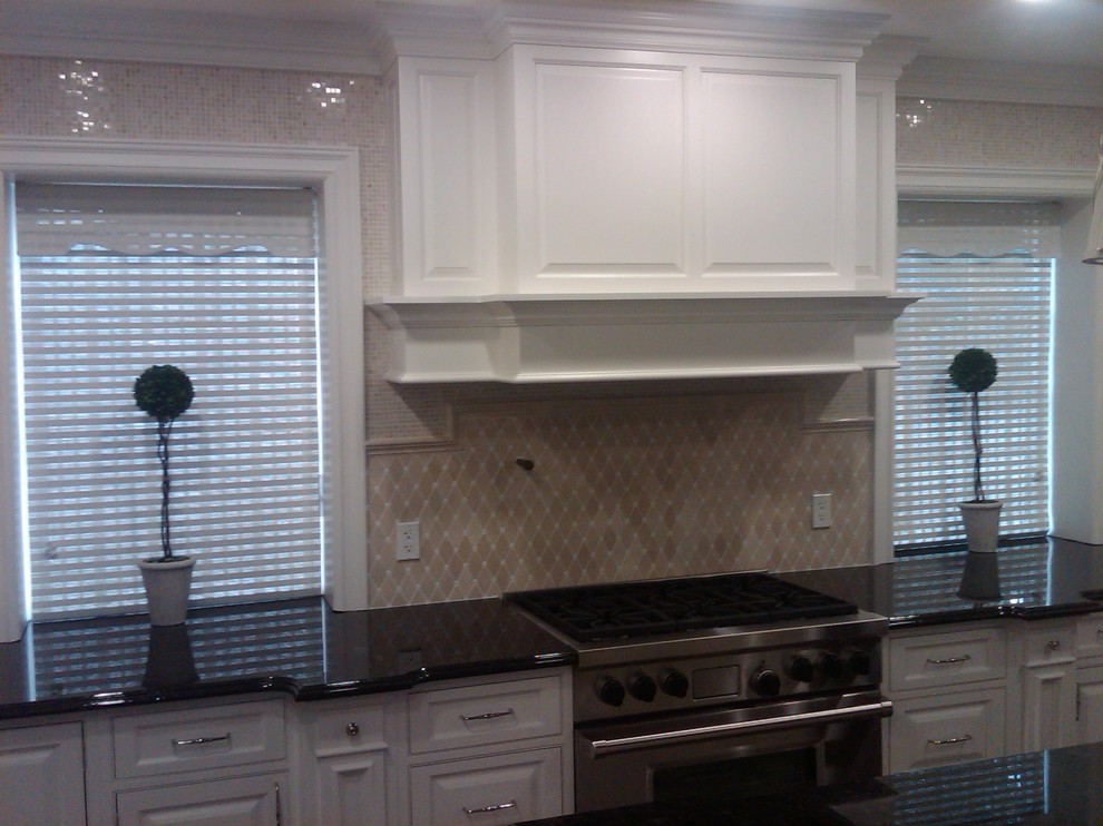 Klassisk inredning av ett avskilt, mellanstort u-kök, med luckor med upphöjd panel, vita skåp, beige stänkskydd, stänkskydd i keramik och en köksö