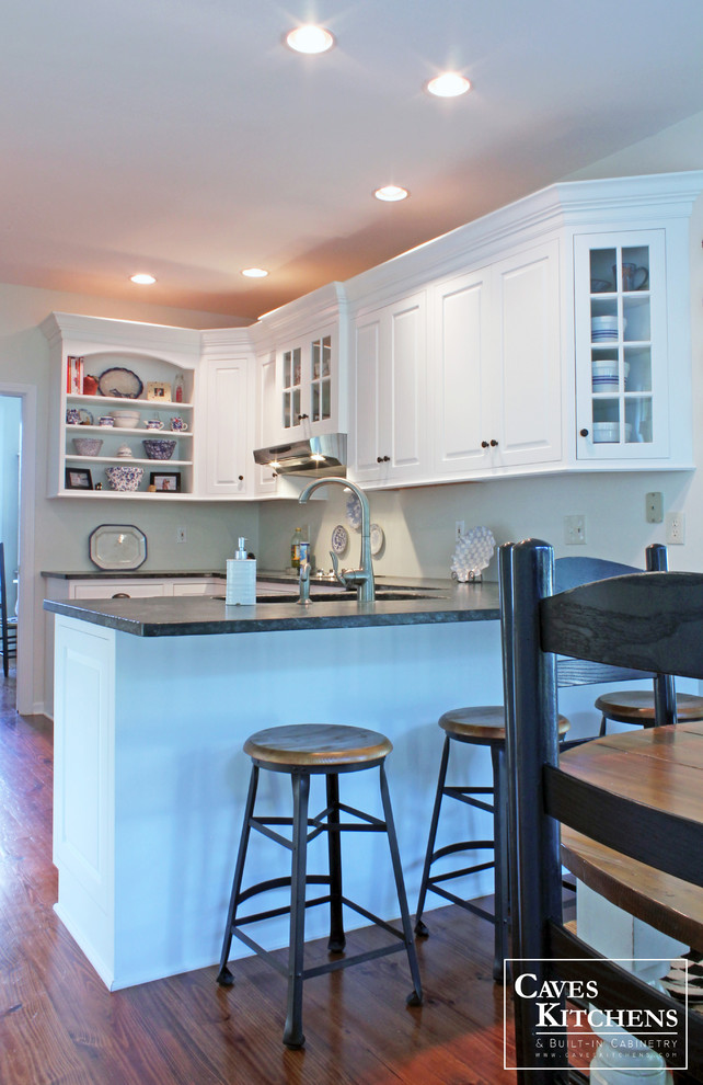 Bild på ett mellanstort vintage kök, med en undermonterad diskho, luckor med upphöjd panel, vita skåp, grönt stänkskydd, rostfria vitvaror, mörkt trägolv och en halv köksö