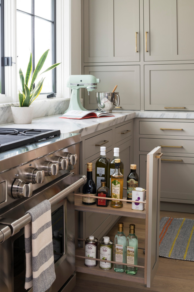 Inspiration pour une grande cuisine traditionnelle en L et bois clair avec un évier encastré, un placard à porte shaker, plan de travail en marbre, une crédence blanche, une crédence en marbre, un électroménager en acier inoxydable, parquet clair, îlot, un sol beige et un plan de travail blanc.