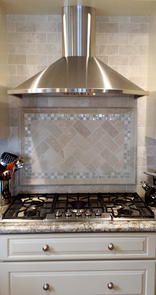 Inspiration for a coastal kitchen remodel in Philadelphia with white cabinets, granite countertops, beige backsplash, stone tile backsplash and stainless steel appliances
