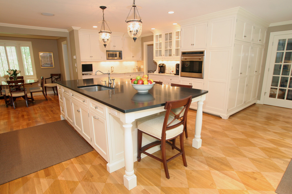 Elegant eat-in kitchen photo in Boston with glass-front cabinets, an undermount sink and white cabinets