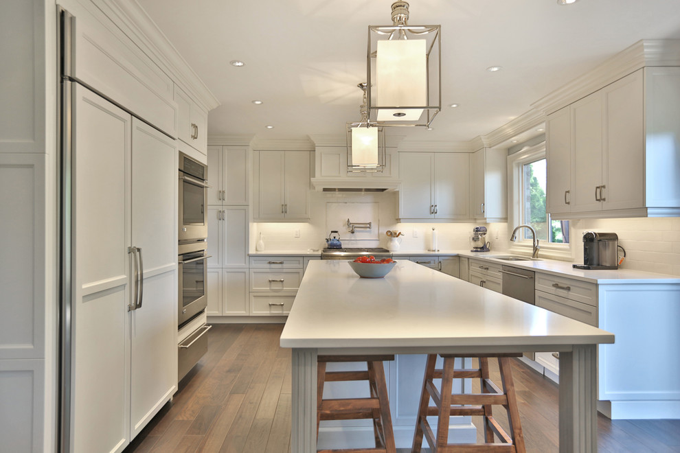 Inspiration for a large classic kitchen in Toronto with a submerged sink, shaker cabinets, white cabinets, quartz worktops, white splashback, dark hardwood flooring and an island.