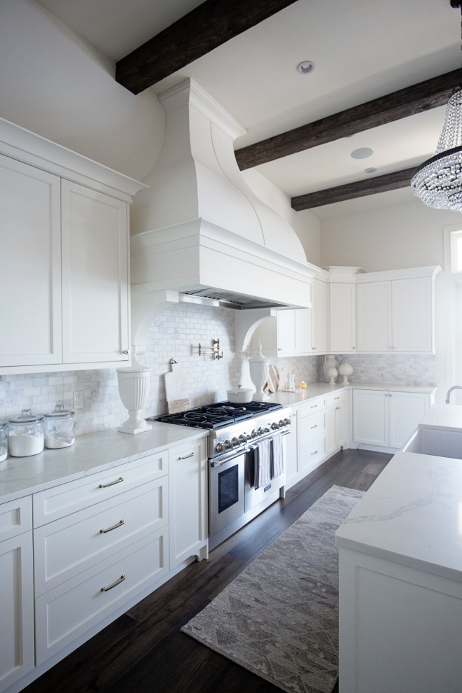 Exempel på ett stort maritimt vit vitt kök, med en rustik diskho, skåp i shakerstil, vita skåp, bänkskiva i kvartsit, vitt stänkskydd, stänkskydd i keramik, integrerade vitvaror, mörkt trägolv, en köksö och brunt golv