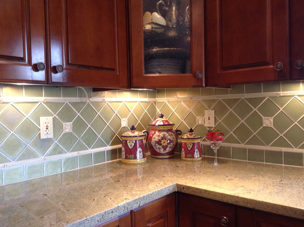 Exempel på ett klassiskt kök och matrum, med en undermonterad diskho, luckor med profilerade fronter, skåp i mellenmörkt trä, granitbänkskiva, grönt stänkskydd, rostfria vitvaror, skiffergolv och en köksö