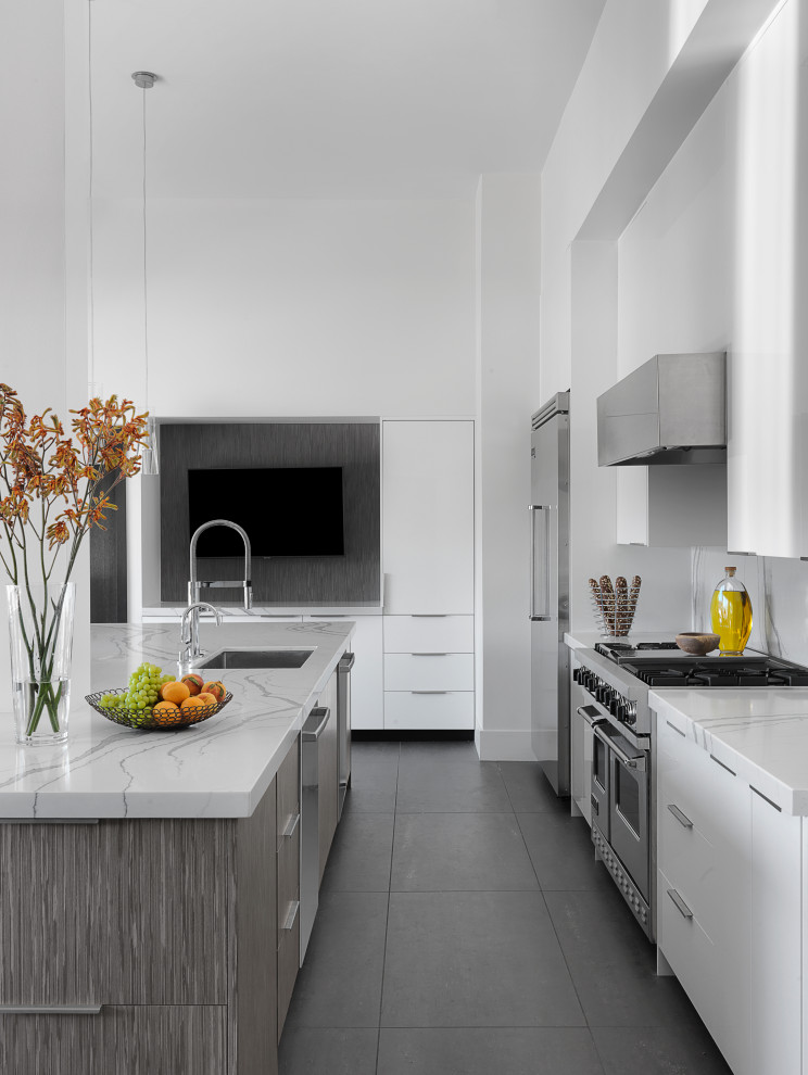 Large modern kitchen/diner in St Louis with a submerged sink, flat-panel cabinets, white cabinets, engineered stone countertops, white splashback, engineered quartz splashback, stainless steel appliances, ceramic flooring, an island, grey floors and white worktops.