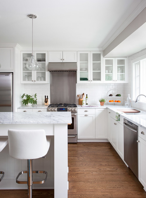 Modern white kitchen with premium RTA cabinets Canada shaker cabinets , marble countertops, stainless steel appliances and warm wood floors.