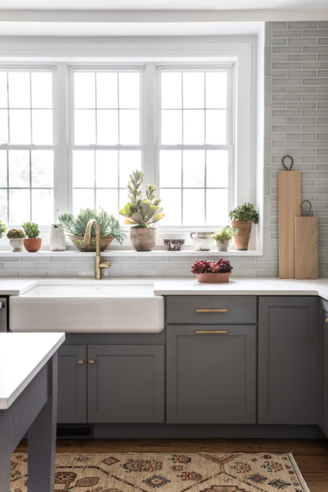 ボストンにある高級な広いトランジショナルスタイルのおしゃれなキッチン (青いキャビネット、グレーのキッチンパネル、セラミックタイルのキッチンパネル、シルバーの調理設備、無垢フローリング、茶色い床、白いキッチンカウンター) の写真