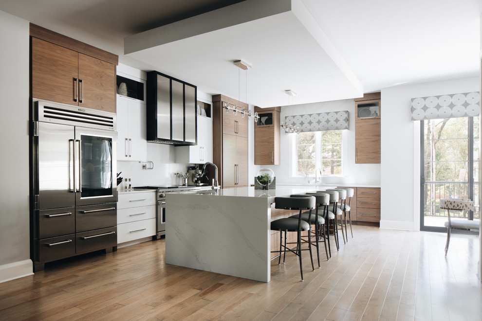 Inspiration for a mid-sized contemporary l-shaped light wood floor kitchen remodel in Chicago with an undermount sink, flat-panel cabinets, medium tone wood cabinets, quartz countertops, white backsplash, an island and white countertops