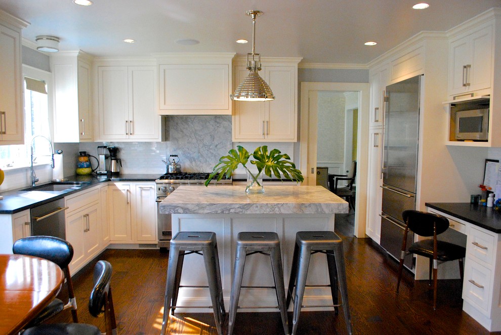 Mid-sized transitional u-shaped dark wood floor eat-in kitchen photo in New York with an undermount sink, shaker cabinets, white cabinets, marble countertops, gray backsplash, stainless steel appliances and an island