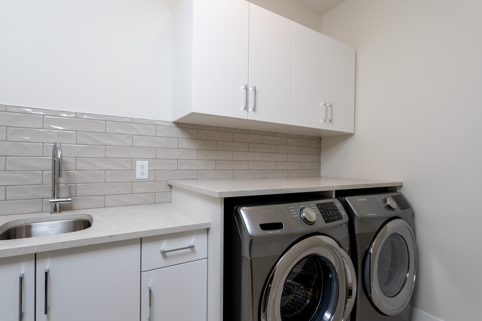 Photo of a contemporary l-shaped utility room in Edmonton with a submerged sink, flat-panel cabinets, white cabinets and white worktops.