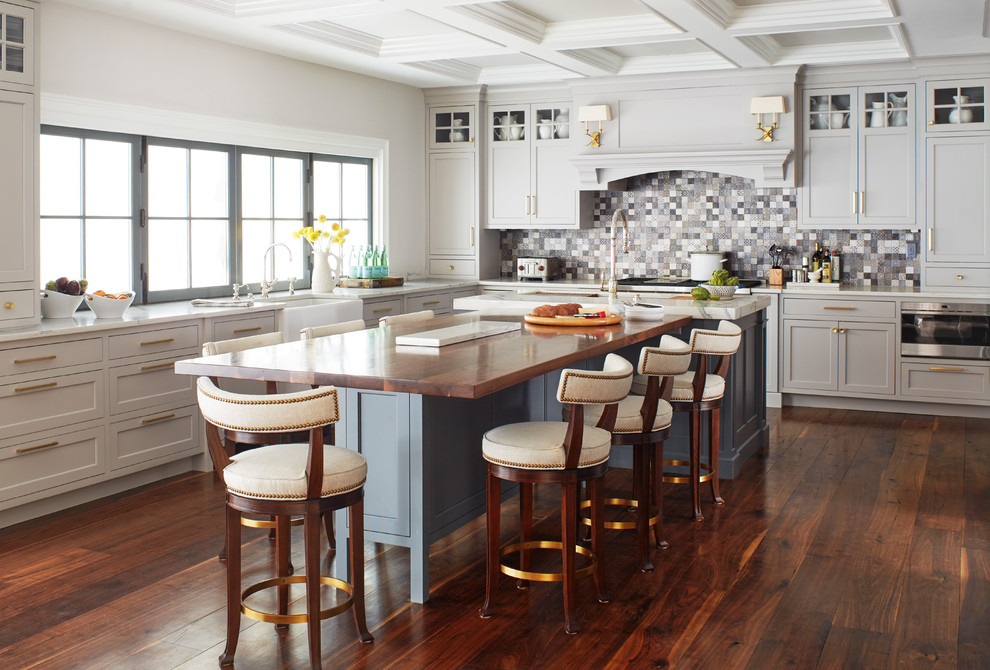 Klassische Küche in L-Form mit Landhausspüle, Schrankfronten im Shaker-Stil, grauen Schränken, Küchenrückwand in Grau, Küchengeräten aus Edelstahl, dunklem Holzboden und Kücheninsel in New York