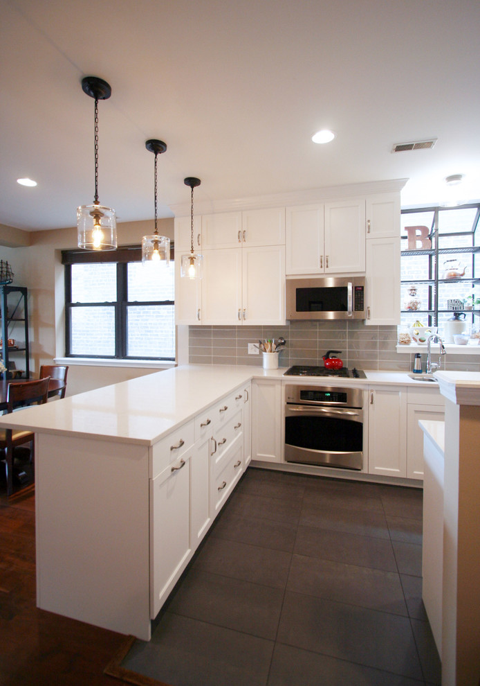 Mid-sized transitional u-shaped porcelain tile open concept kitchen photo in Chicago with an undermount sink, shaker cabinets, white cabinets, quartzite countertops, gray backsplash, subway tile backsplash, stainless steel appliances and a peninsula