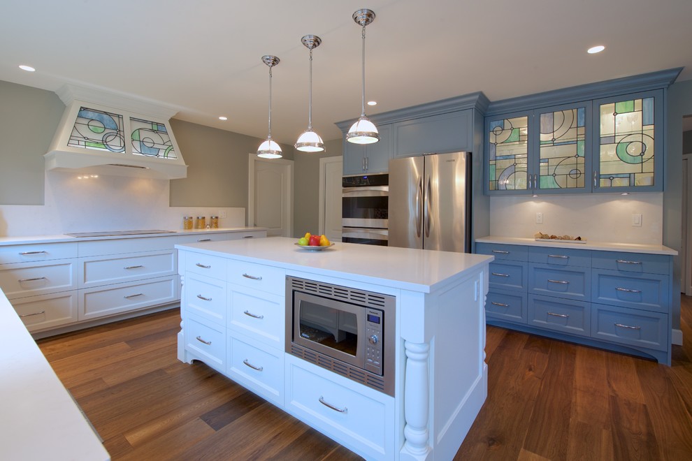 Exempel på ett mellanstort klassiskt kök, med en undermonterad diskho, luckor med profilerade fronter, vita skåp, bänkskiva i kvartsit, vitt stänkskydd, stänkskydd i sten, integrerade vitvaror, mellanmörkt trägolv, en köksö och brunt golv