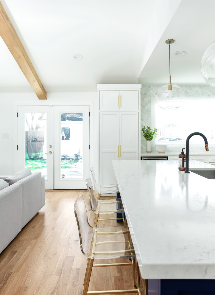 Diseño de cocinas en L actual, grande, abierta, con fregadero bajoencimera, armarios estilo shaker, puertas de armario blancas, encimera de cuarzo compacto, salpicadero blanco, salpicadero de mármol, electrodomésticos de acero inoxidable, suelo de madera clara, una isla, suelo marrón y encimeras blancas