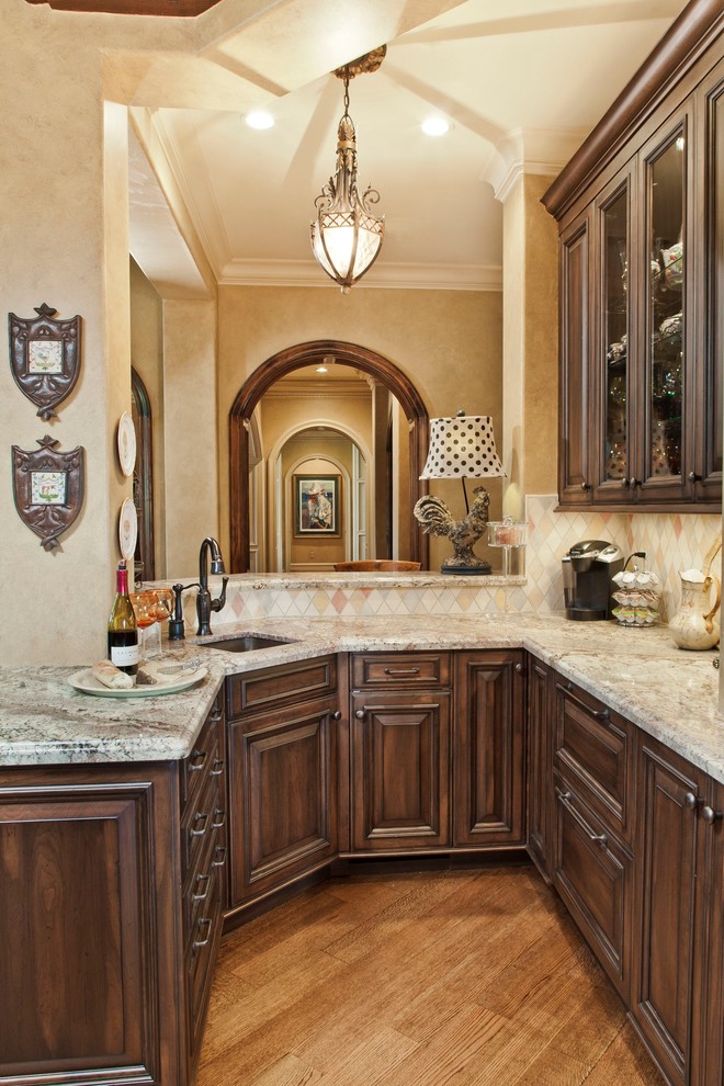 Example of a classic u-shaped medium tone wood floor eat-in kitchen design in Houston with an undermount sink, dark wood cabinets, granite countertops, multicolored backsplash and paneled appliances