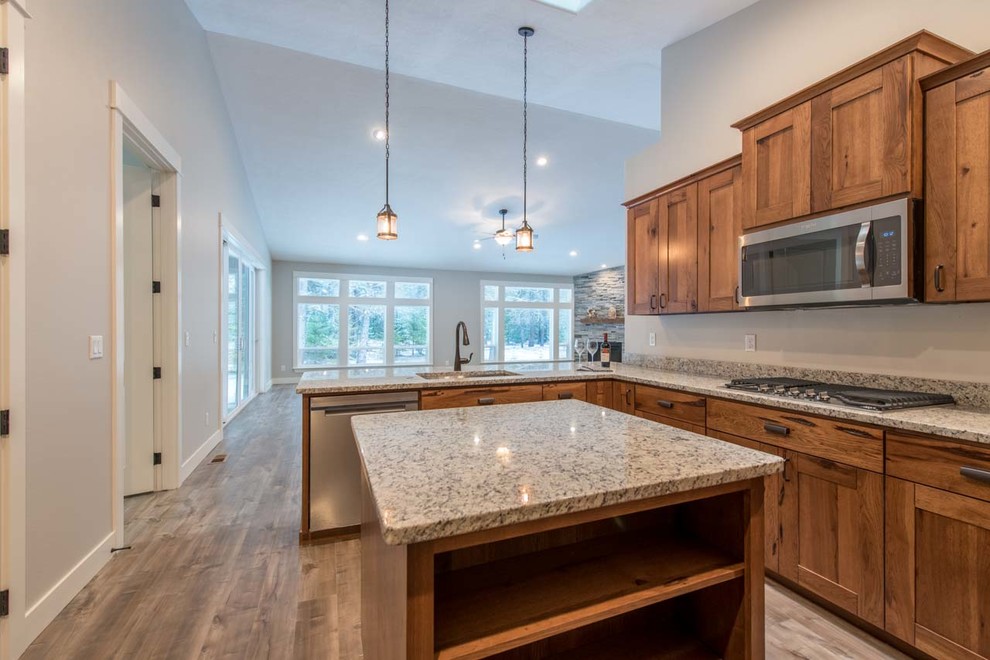 Example of a mid-sized arts and crafts u-shaped dark wood floor and brown floor enclosed kitchen design in Other with an undermount sink, shaker cabinets, dark wood cabinets, quartz countertops, stainless steel appliances, an island and gray countertops