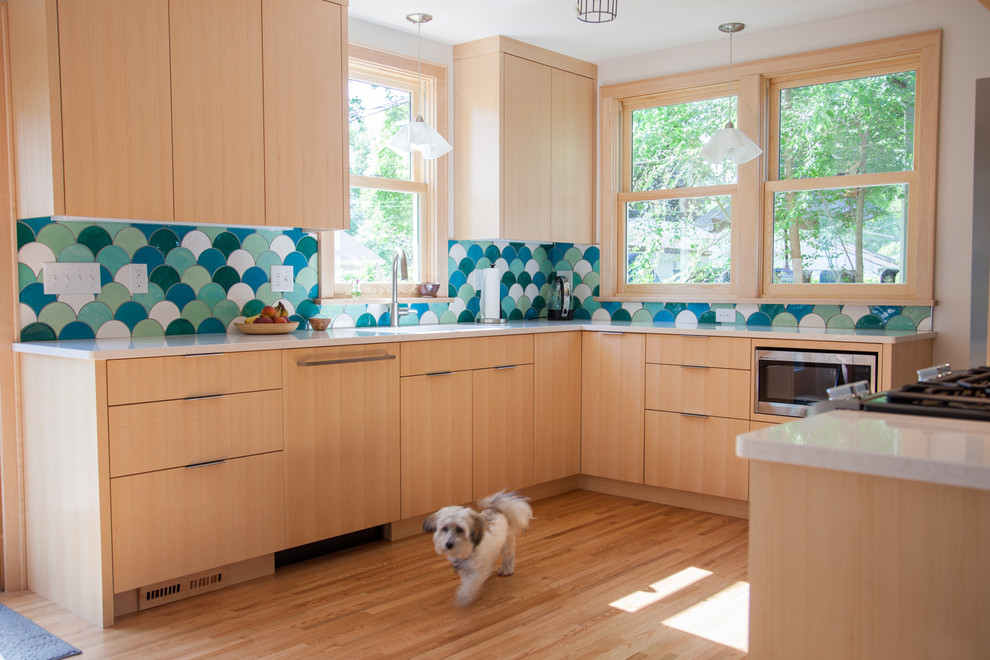 Idéer för ett stort modernt kök, med en undermonterad diskho, släta luckor, skåp i ljust trä, blått stänkskydd, stänkskydd i keramik, rostfria vitvaror, ljust trägolv, bänkskiva i kvarts och brunt golv