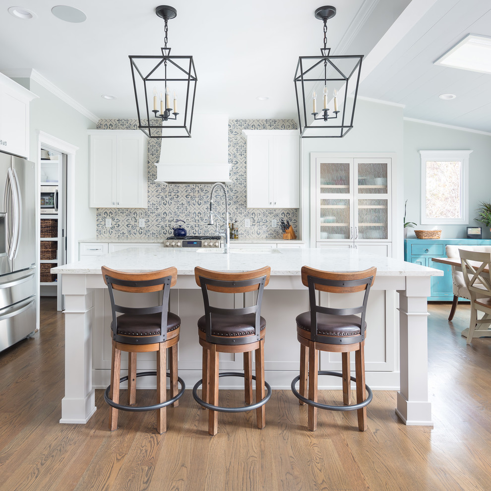 Inspiration for a mid-sized transitional l-shaped porcelain tile and white floor eat-in kitchen remodel in Raleigh with an undermount sink, shaker cabinets, white cabinets, multicolored backsplash, porcelain backsplash, stainless steel appliances, an island, wood countertops and white countertops