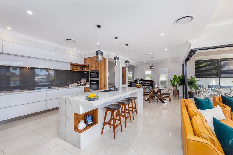 Moderne Küche in L-Form mit flächenbündigen Schrankfronten, weißen Schränken, Küchengeräten aus Edelstahl, Kücheninsel, beigem Boden und weißer Arbeitsplatte in Brisbane