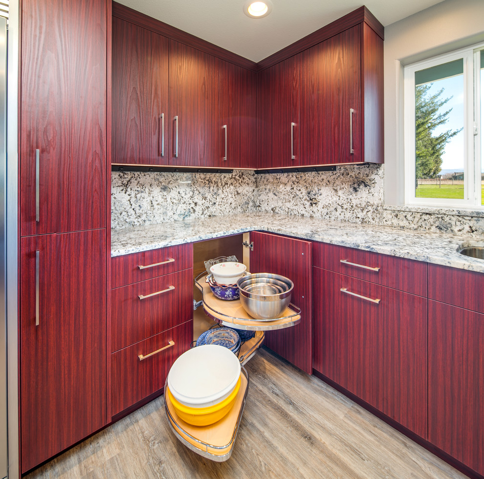 Eat-in kitchen - large modern l-shaped laminate floor and gray floor eat-in kitchen idea in Seattle with an undermount sink, flat-panel cabinets, red cabinets, granite countertops, beige backsplash, stone slab backsplash and beige countertops