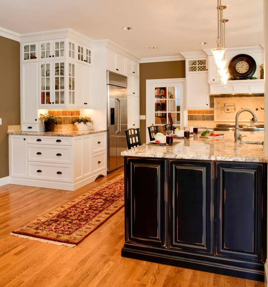 Inredning av ett klassiskt mycket stort kök, med en undermonterad diskho, luckor med upphöjd panel, skåp i slitet trä, granitbänkskiva, flerfärgad stänkskydd, stänkskydd i stenkakel, rostfria vitvaror, mellanmörkt trägolv, en köksö och brunt golv