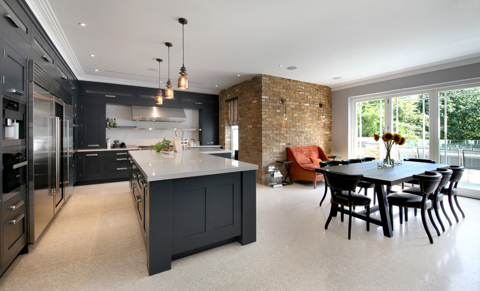 Inspiration for a contemporary l-shaped kitchen/diner in Surrey with shaker cabinets, black cabinets, white splashback, stainless steel appliances, an island and beige floors.
